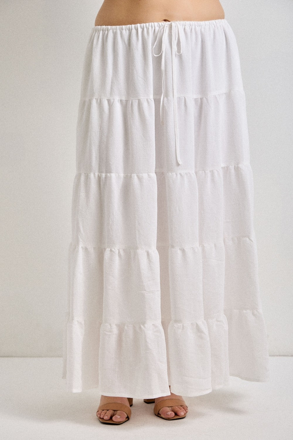 White tiered skirt worn by a person on a white background
